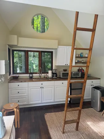 a kitchen with white cabinets and window