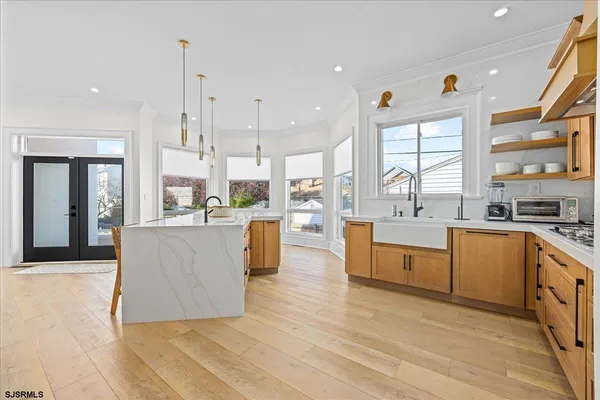 a large kitchen with stainless steel appliances kitchen island granite countertop a large counter top a stove a sink and a large window