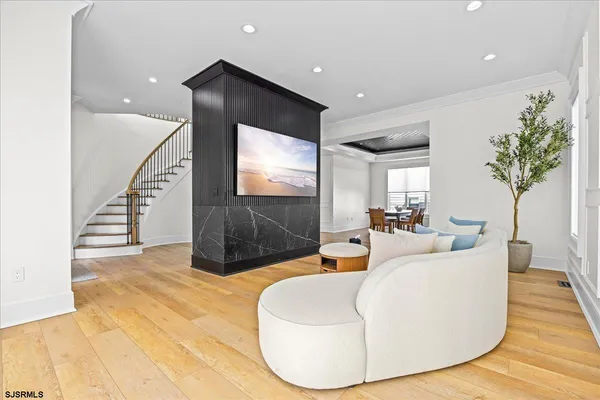 a dining hall with stainless steel appliances kitchen island granite countertop a dining table chairs and view living room
