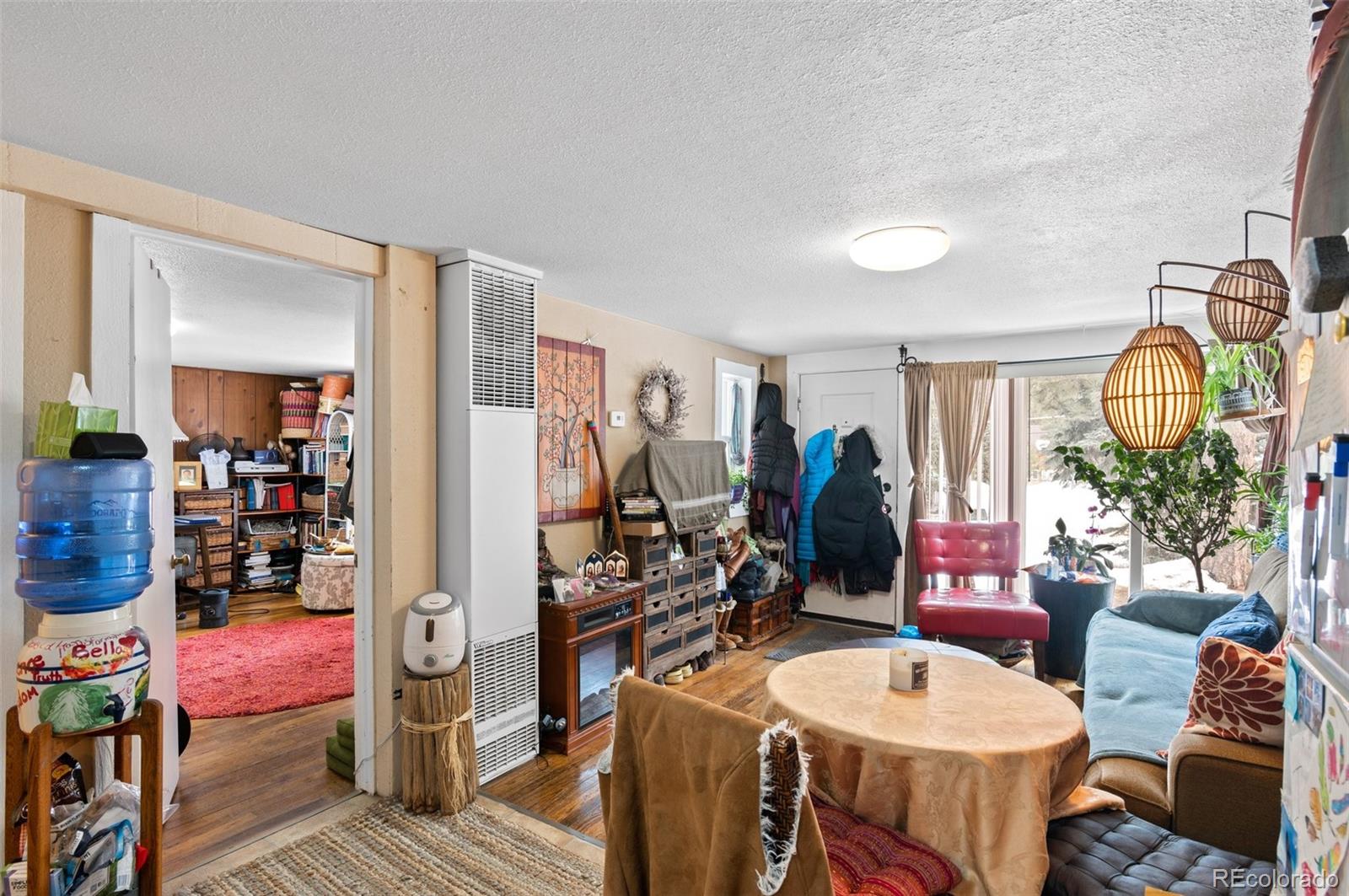 4997 Camel Heights Road Evergreen, CO 80439 - Photo 20 of 24 a living room with furniture a chandelier and a table