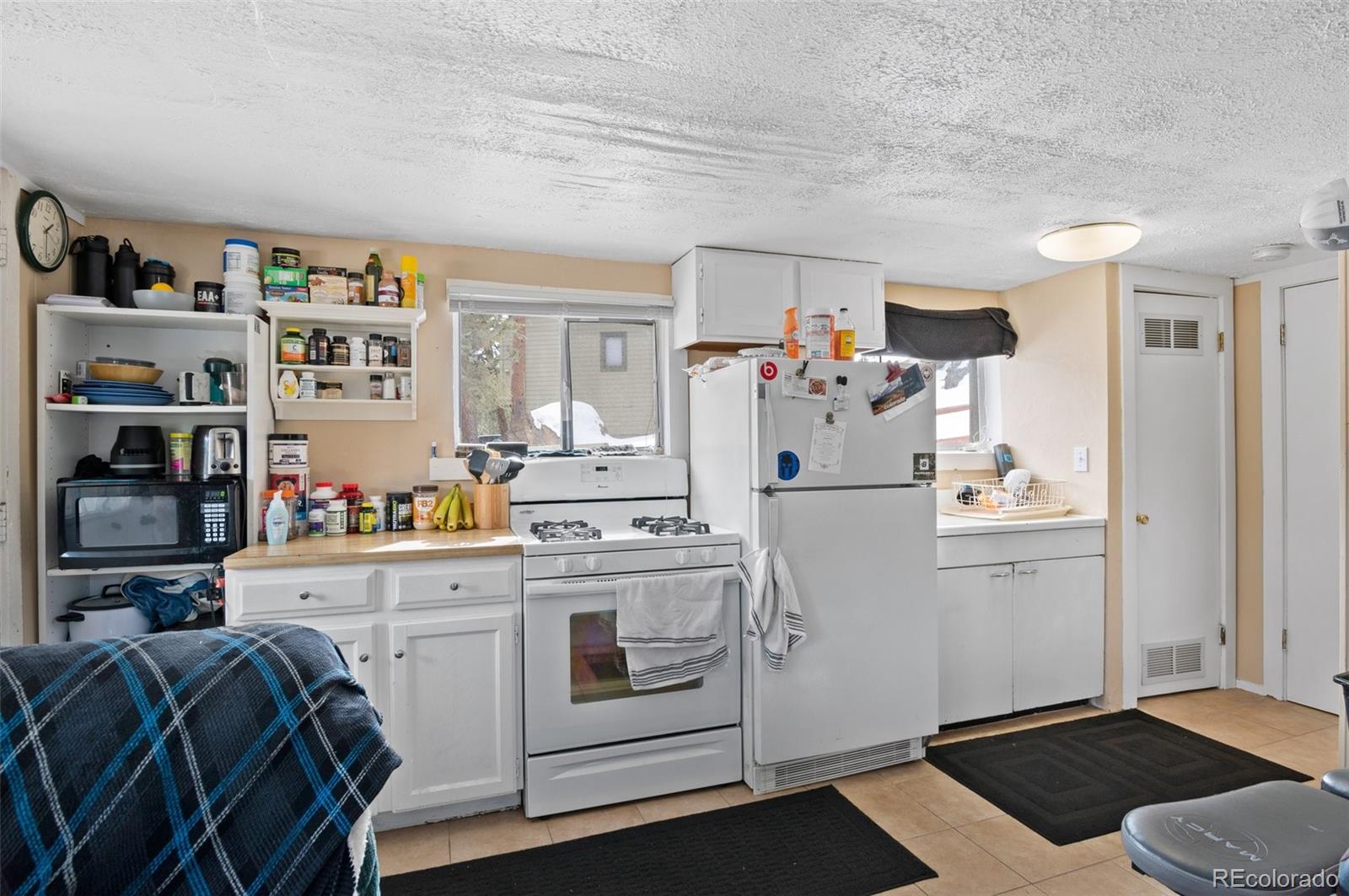 4997 Camel Heights Road Evergreen, CO 80439 - Photo 8 of 24 a kitchen with refrigerator and cabinets