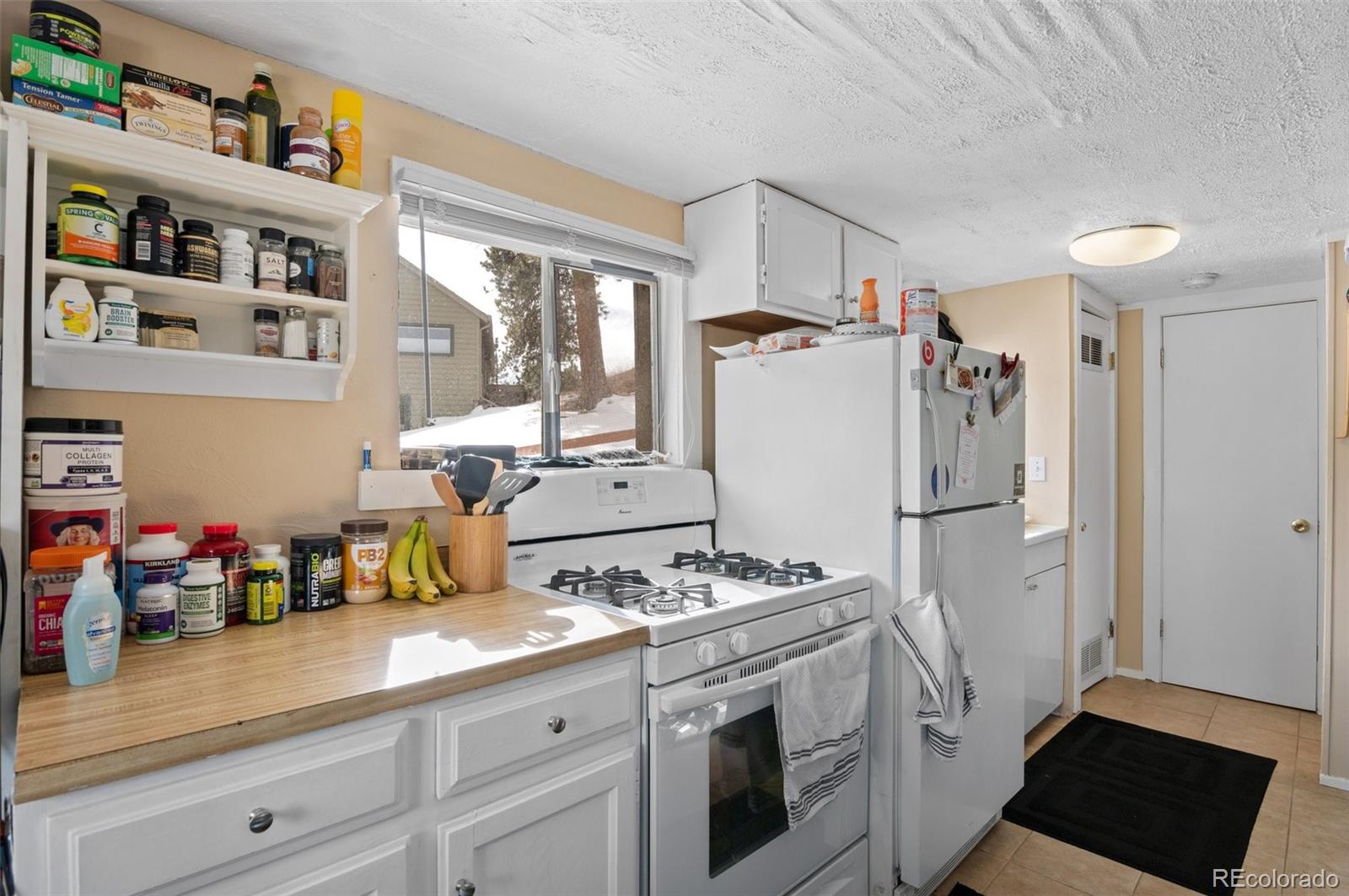 4997 Camel Heights Road Evergreen, CO 80439 - Photo 9 of 24 a kitchen with a refrigerator and a stove