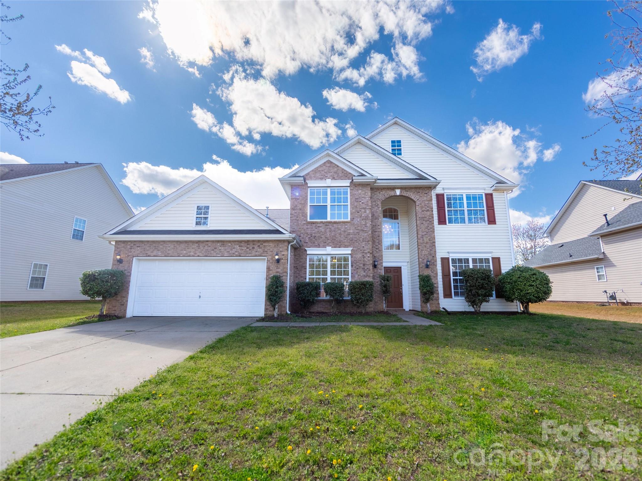 a view of a house with a big yard and a large tree