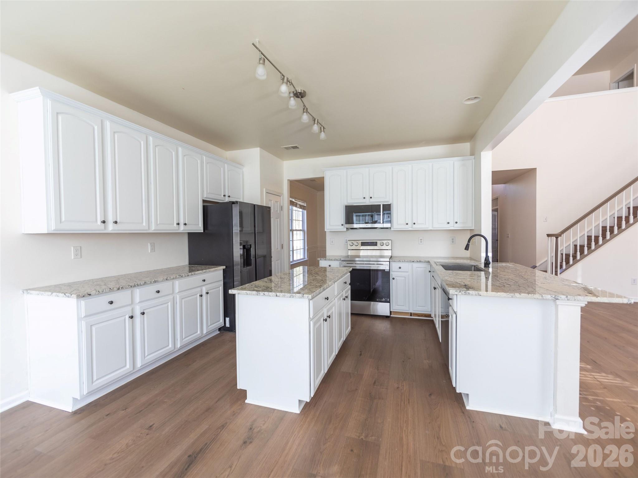 6002 Brook Valley Run Monroe, NC 28110 - Photo 11 of 32 a kitchen with white cabinets and stainless steel appliances