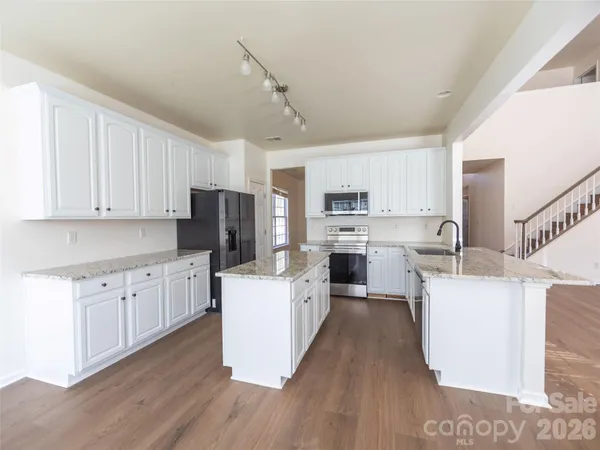 a kitchen with white cabinets and stainless steel appliances