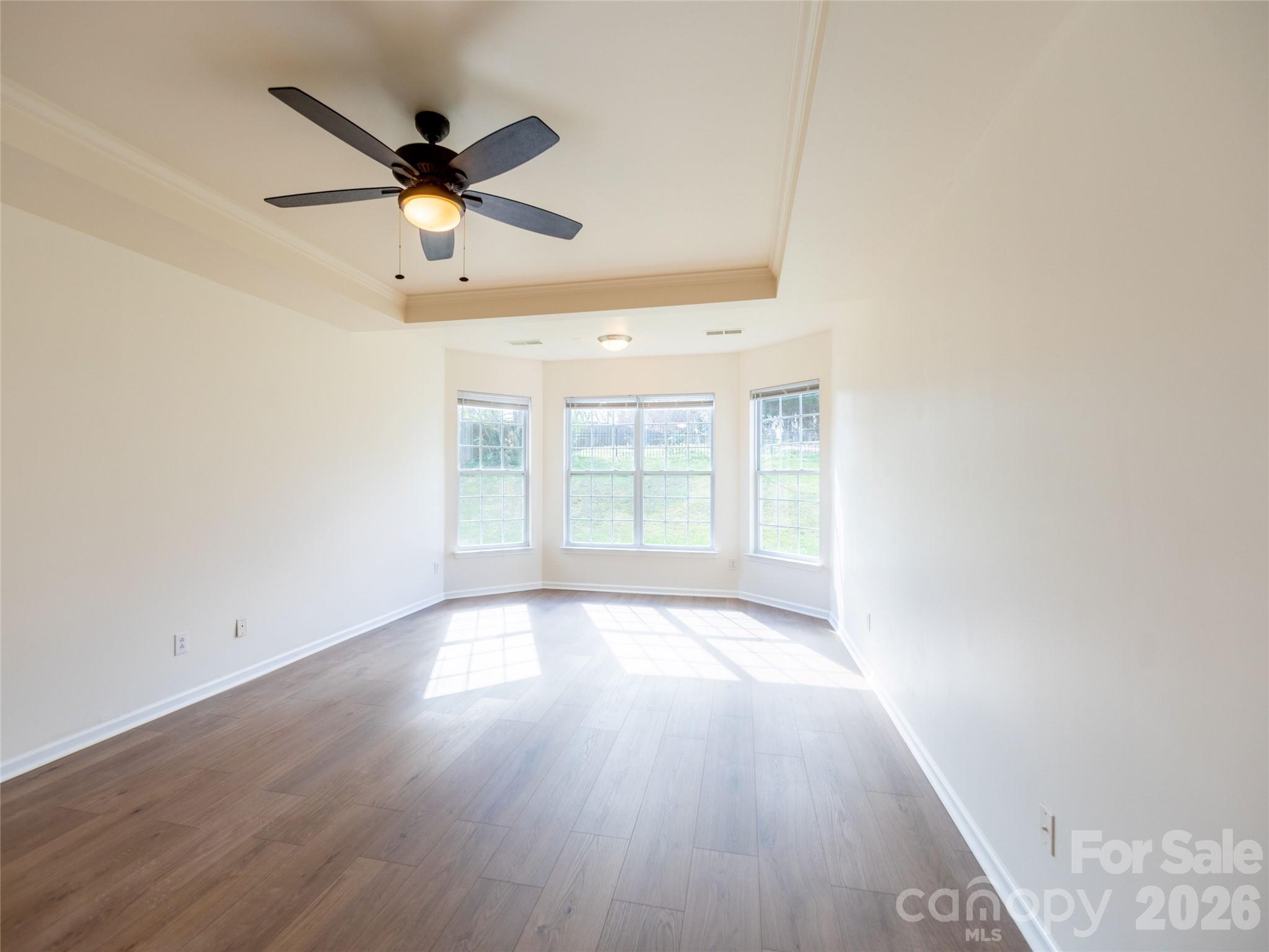 6002 Brook Valley Run Monroe, NC 28110 - Photo 14 of 32 an empty room with wooden floor ceiling fan and window