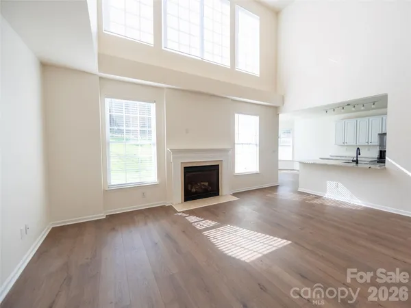 an empty room with windows and a fireplace