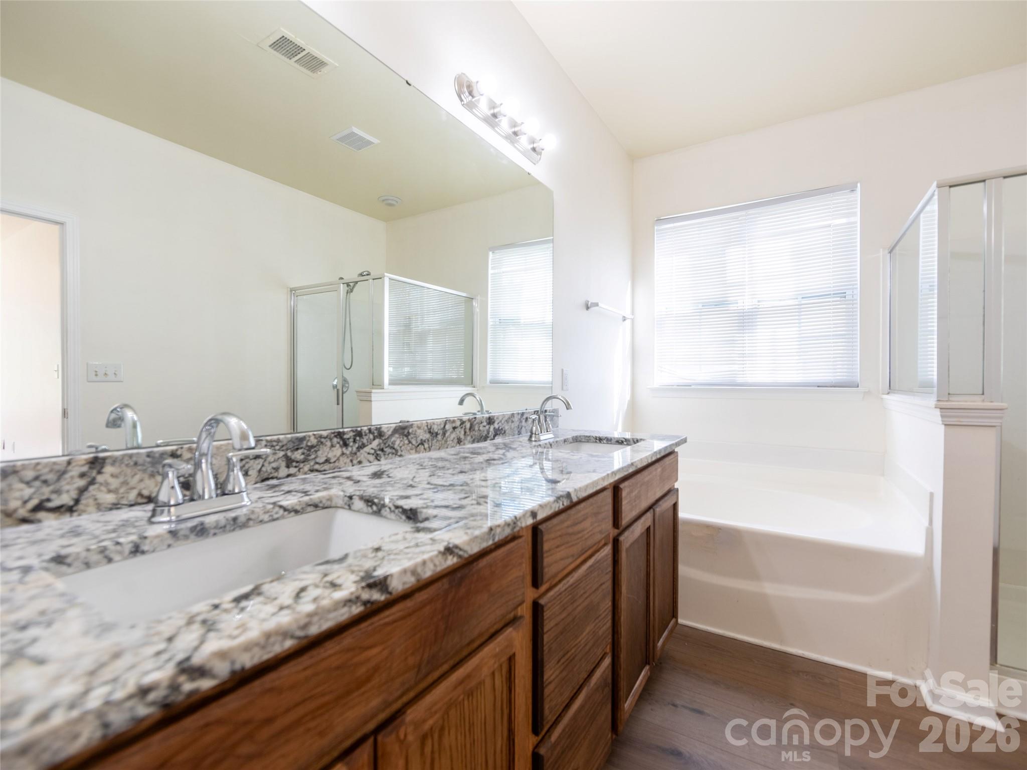 6002 Brook Valley Run Monroe, NC 28110 - Photo 17 of 32 a bathroom with a granite countertop sink mirror and a bath tub