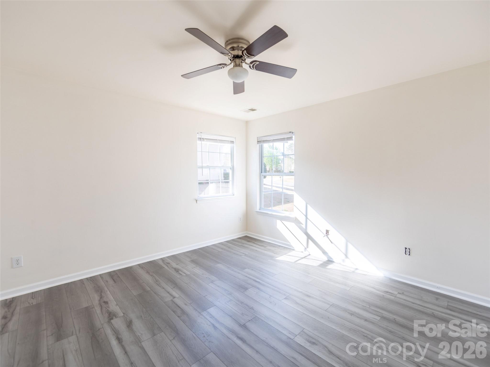 6002 Brook Valley Run Monroe, NC 28110 - Photo 23 of 32 an empty room with wooden floor and windows