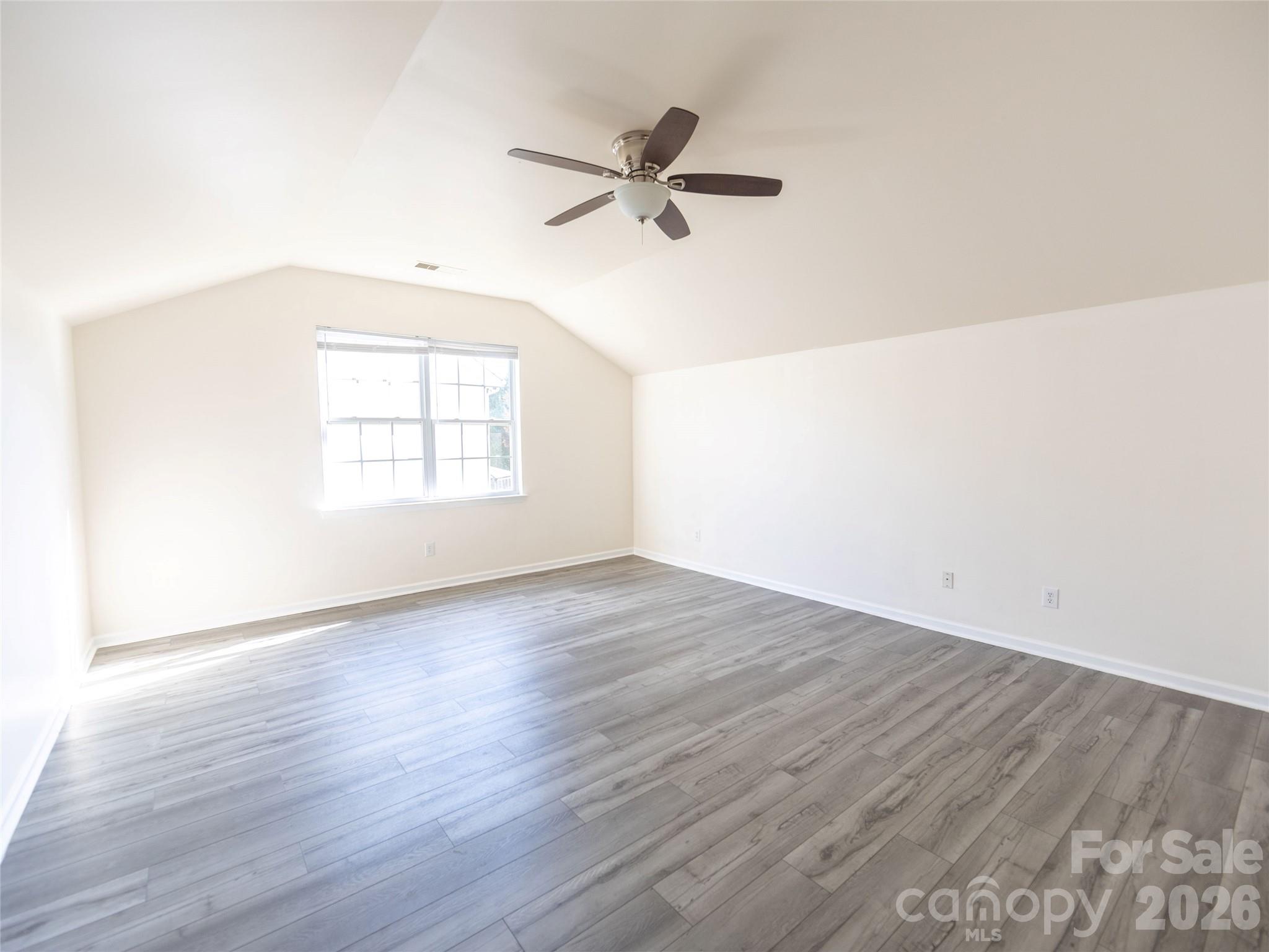 6002 Brook Valley Run Monroe, NC 28110 - Photo 26 of 32 an empty room with wooden floor window and ceiling fan