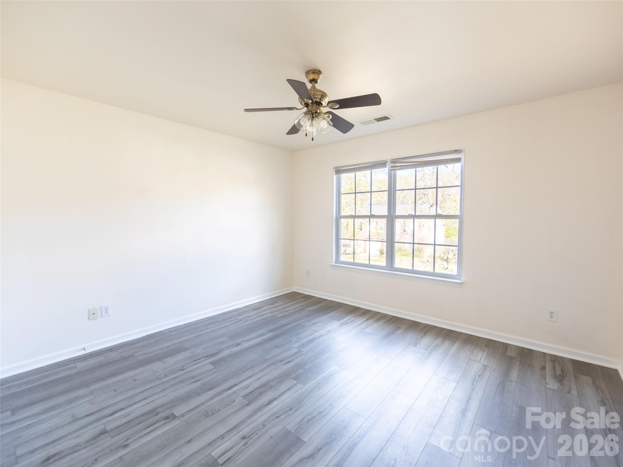 6002 Brook Valley Run Monroe, NC 28110 - Photo 29 of 32 an empty room with wooden floor fan and windows