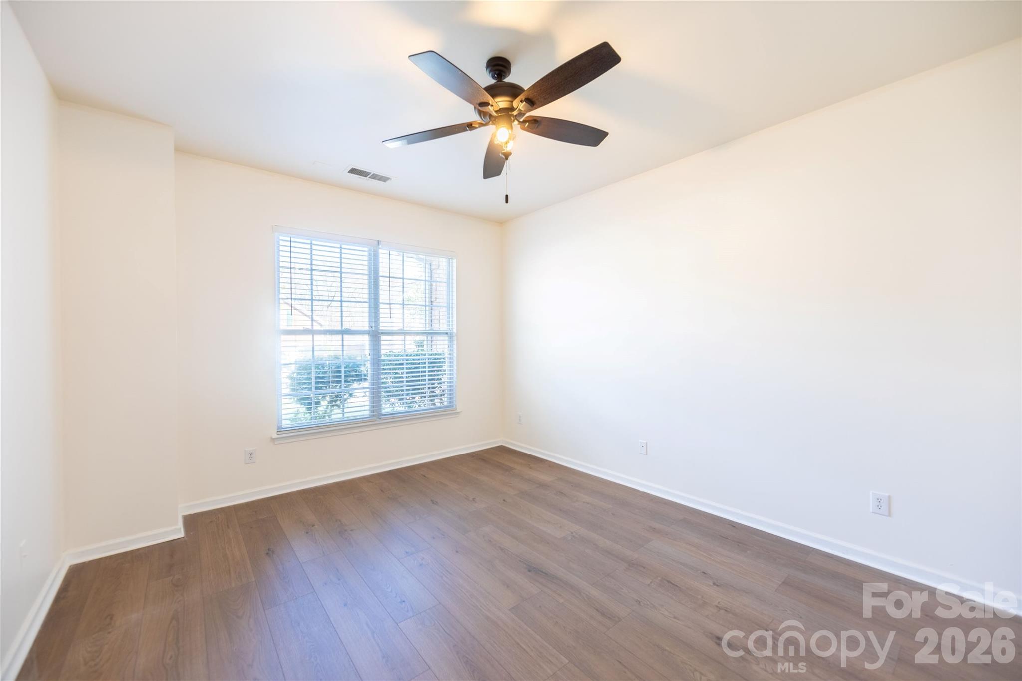 6002 Brook Valley Run Monroe, NC 28110 - Photo 4 of 32 an empty room with wooden floor and ceiling fan