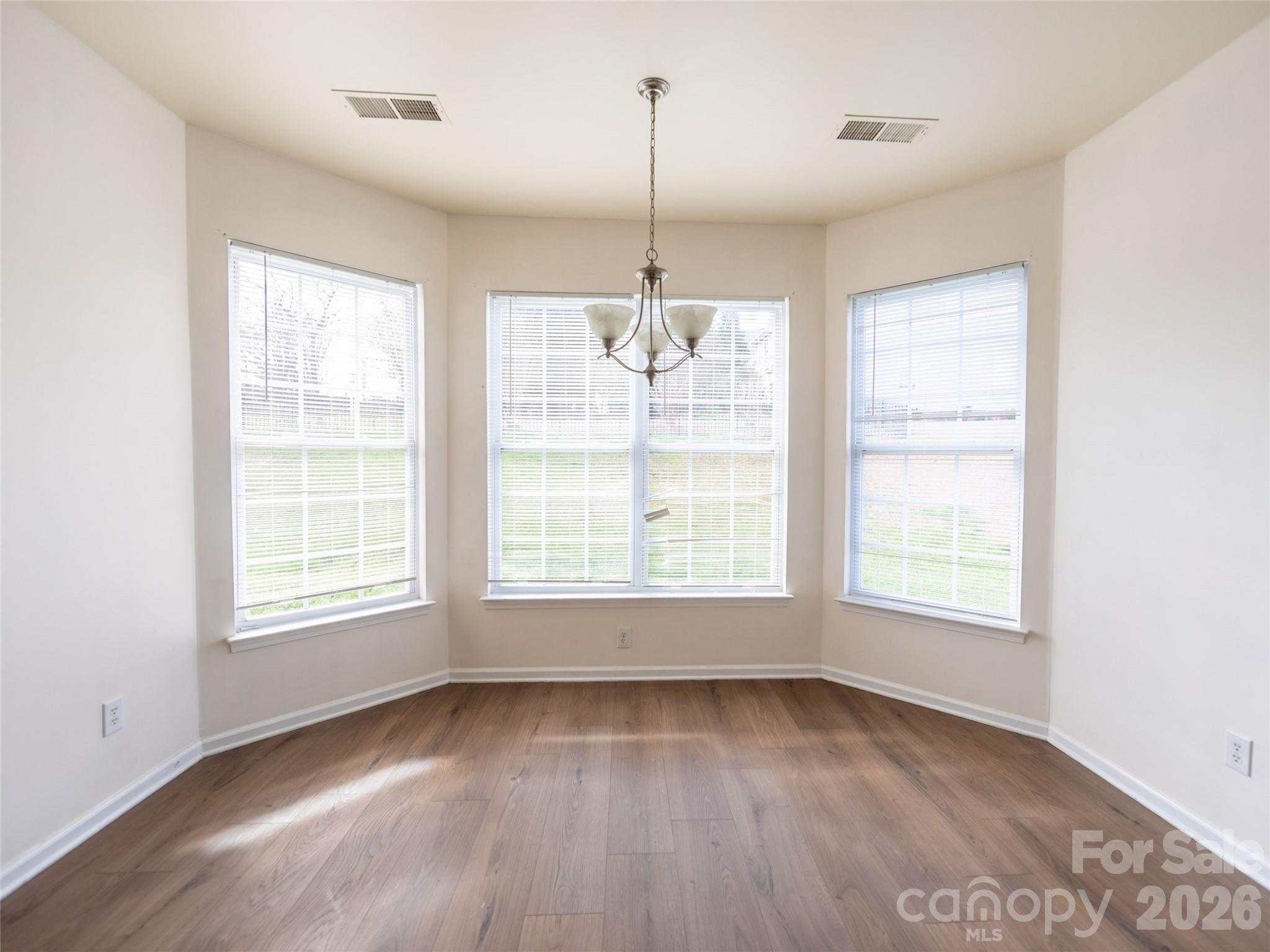 6002 Brook Valley Run Monroe, NC 28110 - Photo 9 of 32 an empty room with wooden floor and windows