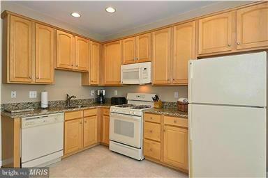 13606 Mills Farm Road Rockville, MD 20850 - Photo 7 of 18 a kitchen with white cabinets and white appliances