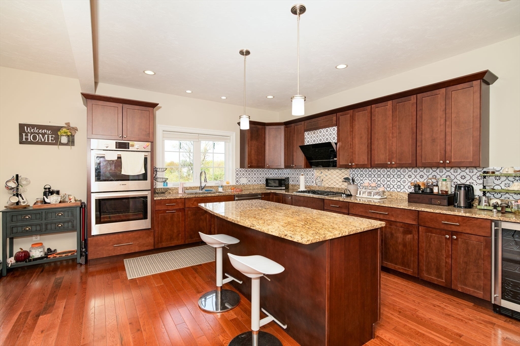 51 Tamarack Road Dracut, MA 01826 - Photo 9 of 39 a kitchen with granite countertop wooden floors appliances and cabinets