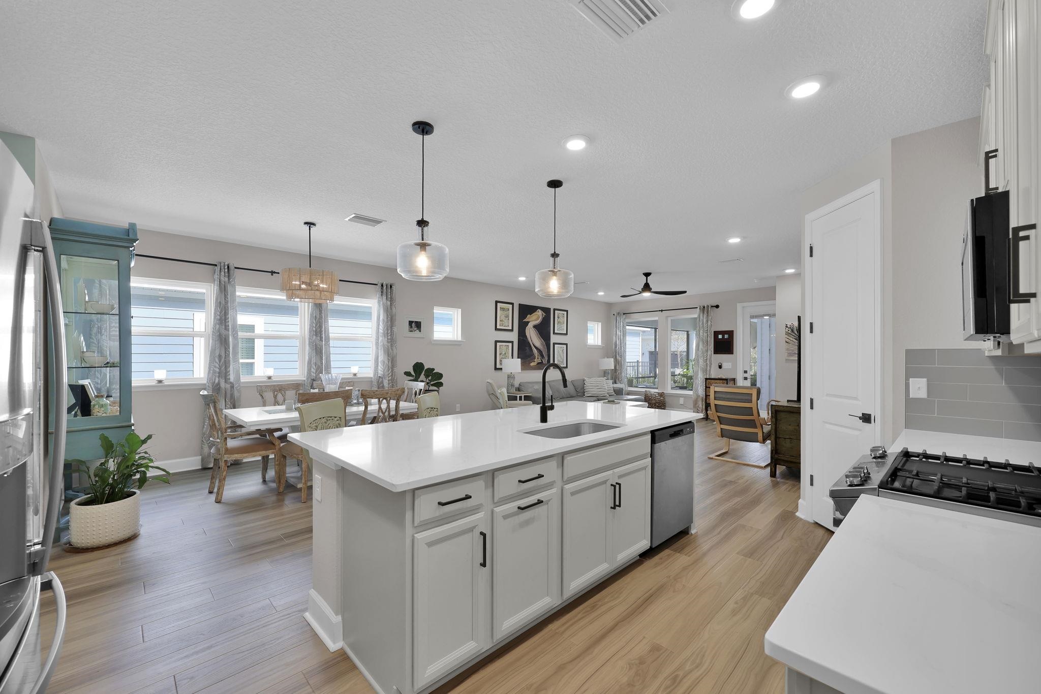 32 Martha Ct. St. Augustine, FL 32092 - Photo 8 of 36 a large kitchen with stainless steel appliances a stove a sink dishwasher and a dining table with wooden floor