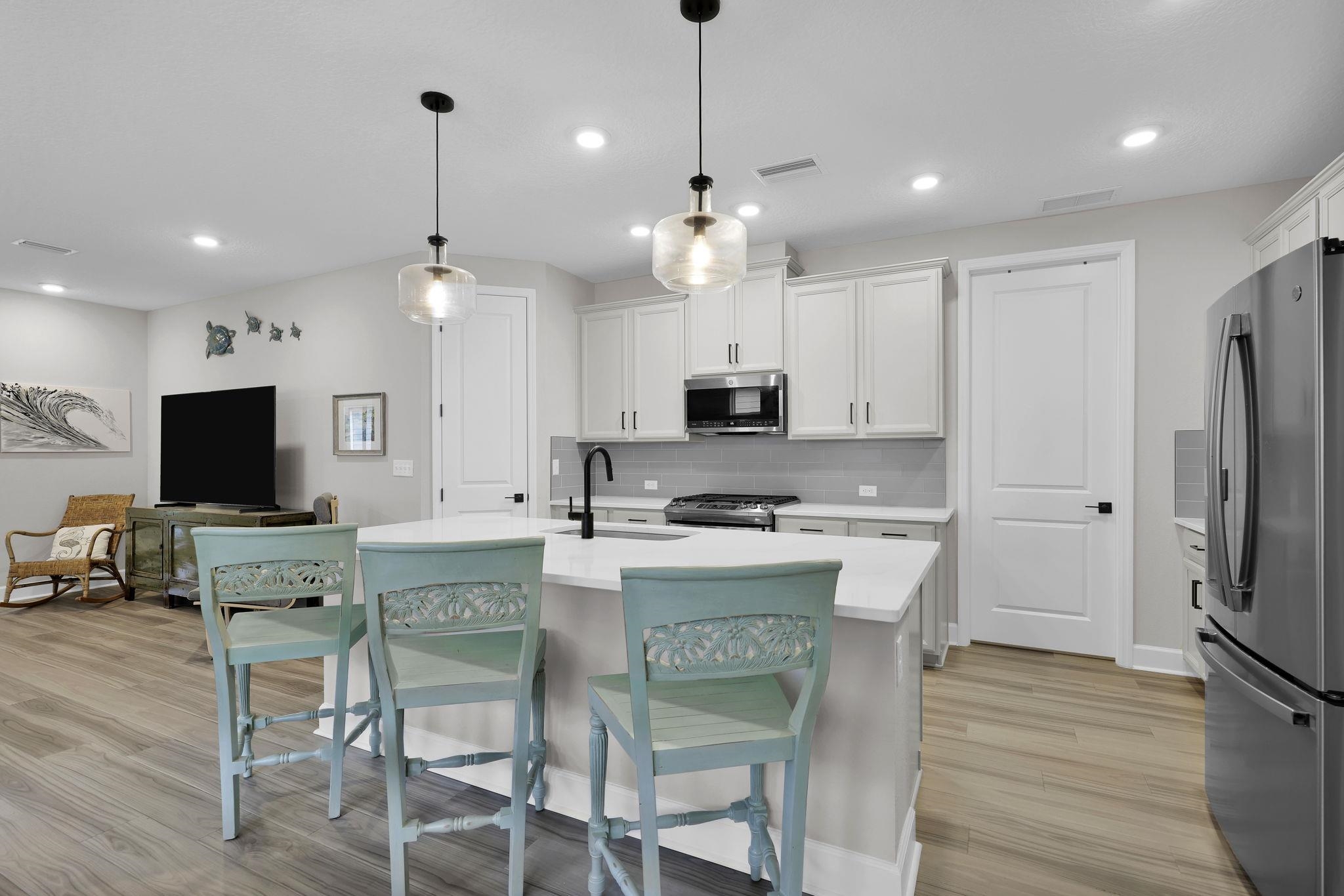32 Martha Ct. St. Augustine, FL 32092 - Photo 9 of 36 a kitchen with kitchen island white cabinets and stainless steel appliances