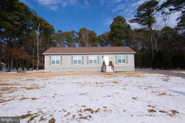 a front view of a house with a dirt yard and a garage