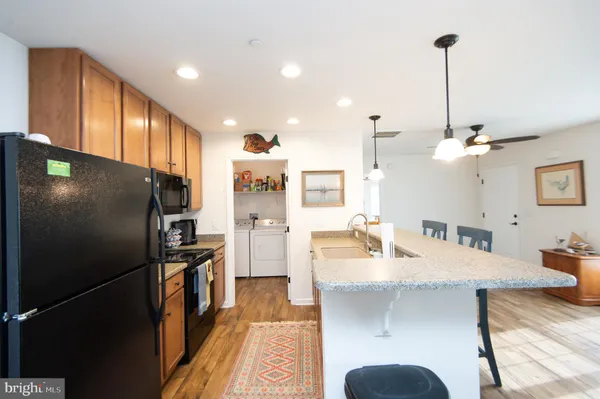 a kitchen with stainless steel appliances kitchen island granite countertop a refrigerator a sink and dishwasher