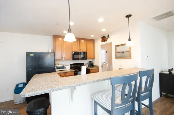 a kitchen with kitchen island a stove a table and chairs