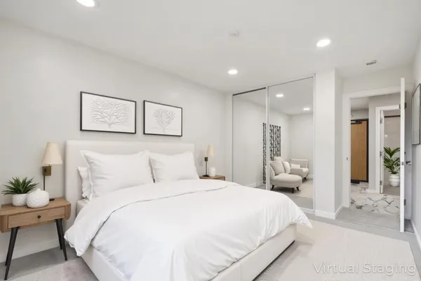 a bedroom with a large bed and painting on the wall