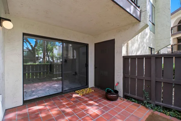 a view of a house with wooden fence next to a yard