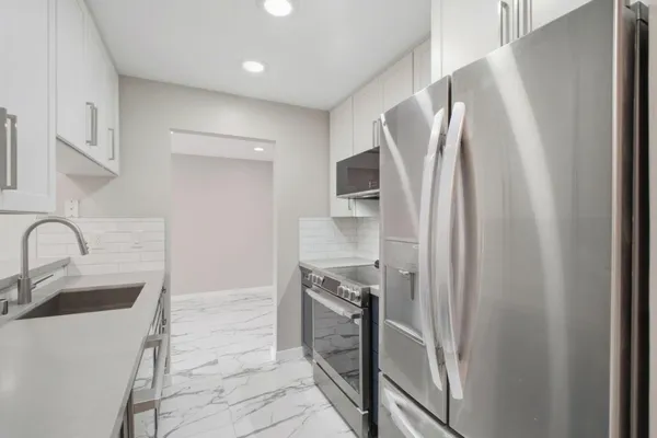 a kitchen with stainless steel appliances a refrigerator and a sink