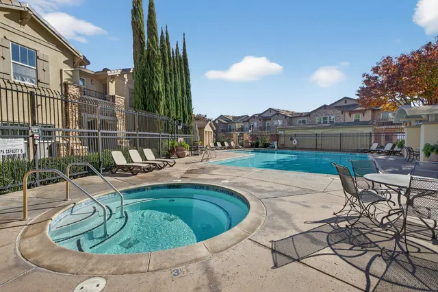 a view of a swimming pool with a patio and a yard