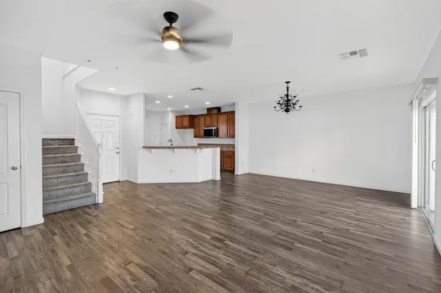 a view of empty room with wooden floor and ceiling fan