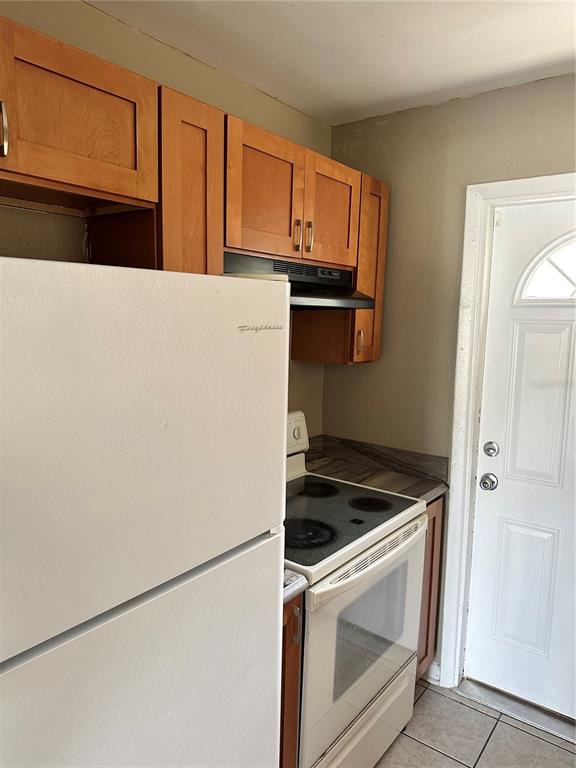 2302 Idaho Road Deltona, FL 32738 - Photo 11 of 22 a kitchen with granite countertop white cabinets and refrigerator