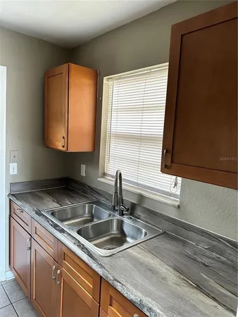 a kitchen with granite countertop white cabinets and refrigerator