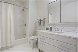 a bathroom with a granite countertop sink toilet and shower