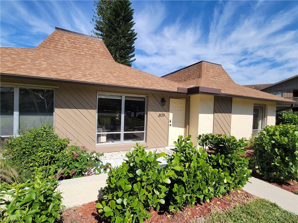809 Palm View Drive, Unit 8 Naples, FL 34110 - Photo 1 of 26 a front view of a house with garden