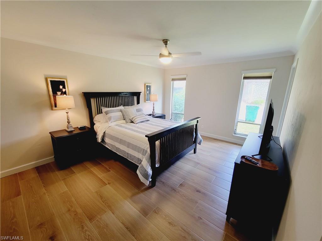 809 Palm View Drive, Unit 8 Naples, FL 34110 - Photo 11 of 26 a spacious bedroom with a bed and wooden floor