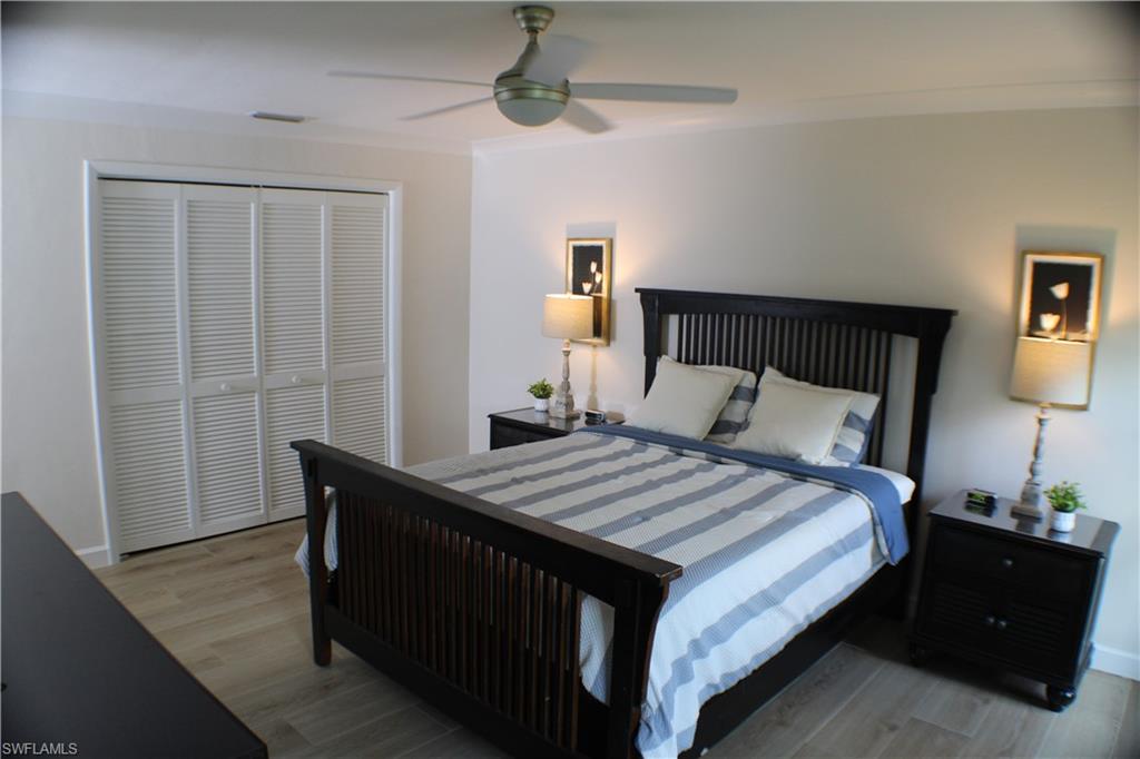 809 Palm View Drive, Unit 8 Naples, FL 34110 - Photo 13 of 26 a bedroom with a bed and wooden floor