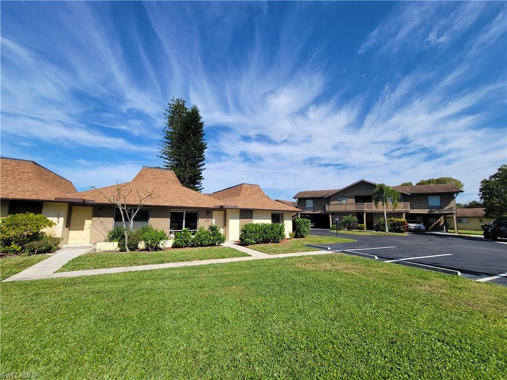 809 Palm View Drive, Unit 8 Naples, FL 34110 - Photo 2 of 26 a front view of house with yard and green space