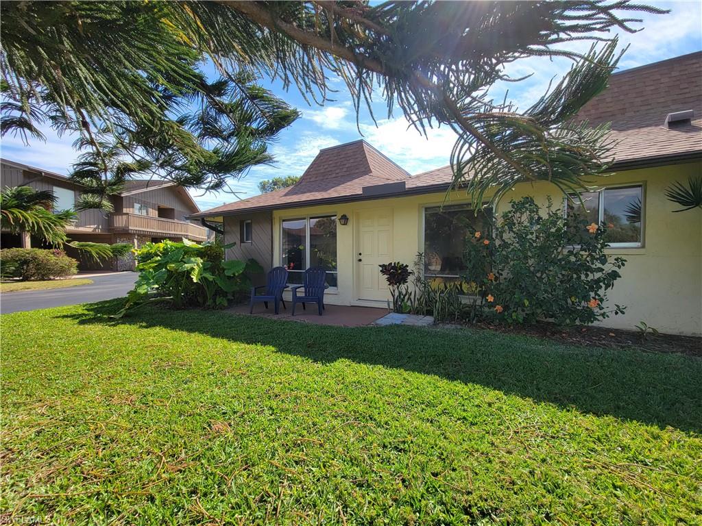 809 Palm View Drive, Unit 8 Naples, FL 34110 - Photo 3 of 26 a front view of a house with garden