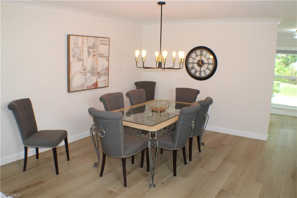 809 Palm View Drive, Unit 8 Naples, FL 34110 - Photo 7 of 26 a dining room with furniture a chandelier and wooden floor