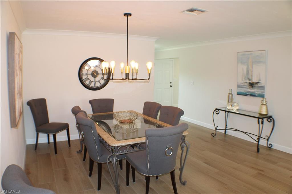 809 Palm View Drive, Unit 8 Naples, FL 34110 - Photo 8 of 26 a view of a dining room with furniture wooden floor and chandelier