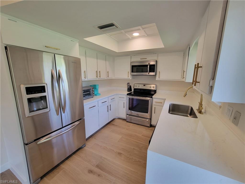 809 Palm View Drive, Unit 8 Naples, FL 34110 - Photo 9 of 26 a kitchen with stainless steel appliances a refrigerator sink and microwave