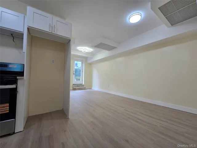 an empty room with wooden floor and fireplace