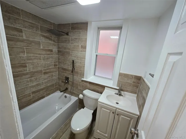 a bathroom with a granite countertop toilet sink and shower