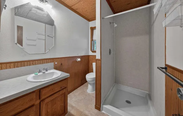 a bathroom with a granite countertop sink a toilet and shower