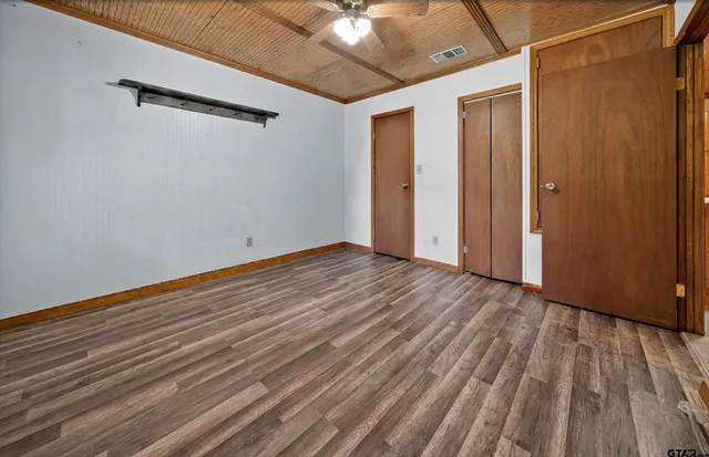 a view of a room with wooden floor and a ceiling fan