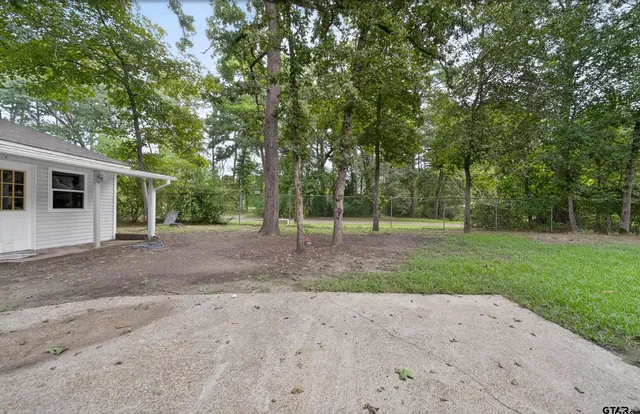 a view of a backyard with large trees