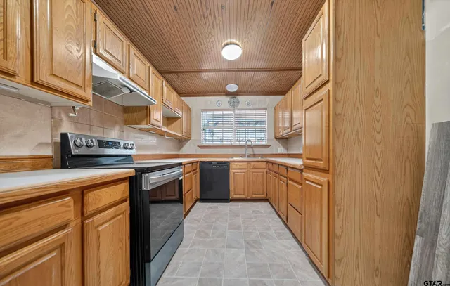 a kitchen with stainless steel appliances granite countertop a sink and white cabinets
