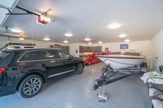 1500 Split Rock, Unit 150 Ivins, UT 84738 - Photo 16 of 18 Spacious garage featuring an epoxy floor coating, multiple overhead light fixtures, and a white paneled door