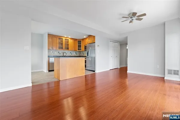 a view of a kitchen with wooden floor and a ceiling fan