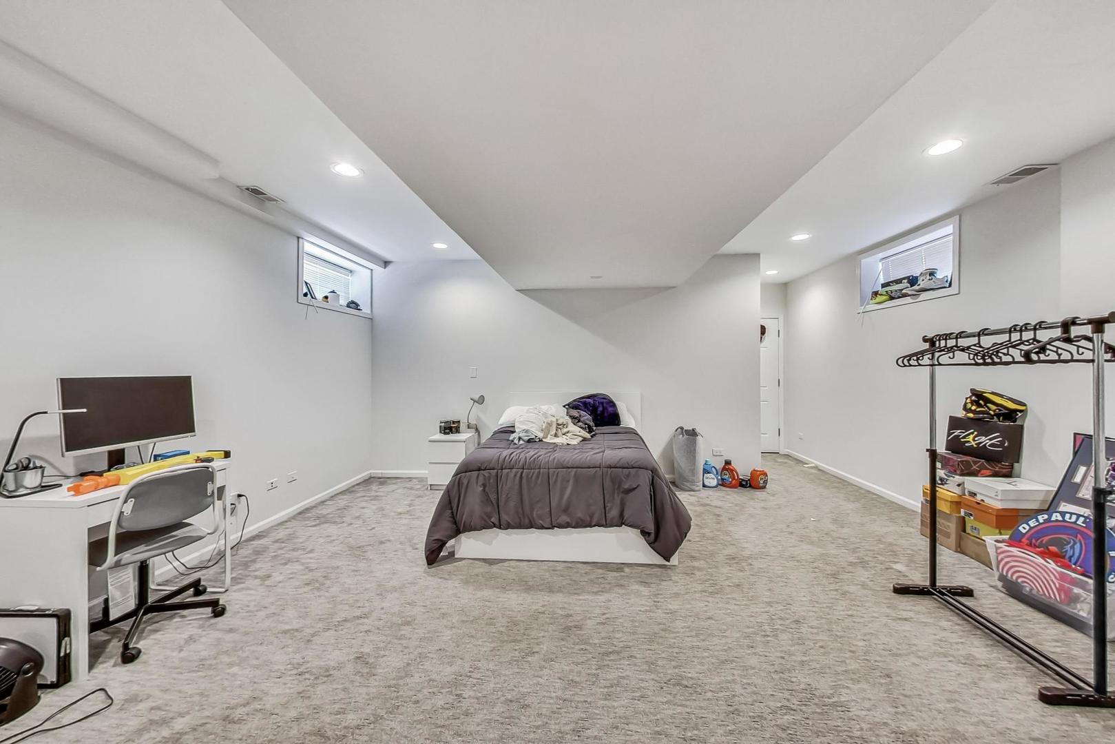 1119 West Addison Street Chicago, IL 60613 - Photo 16 of 36 a bedroom with furniture and a flat screen tv