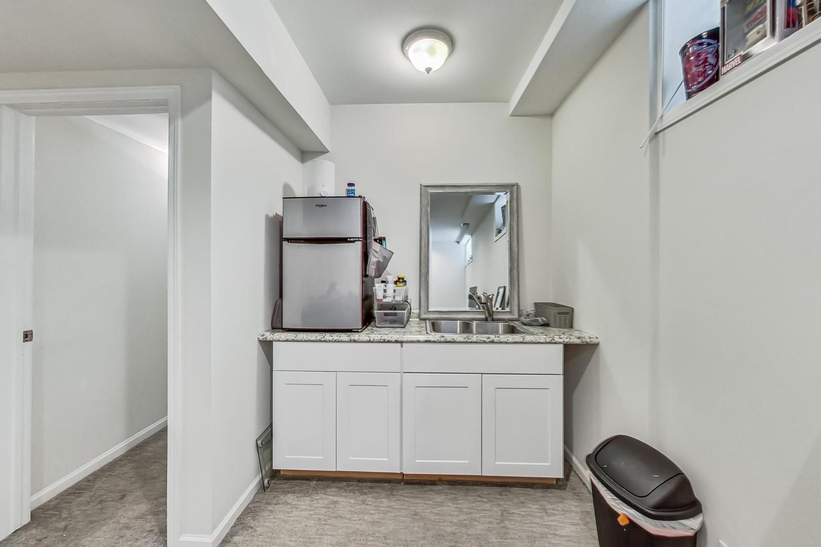1119 West Addison Street Chicago, IL 60613 - Photo 19 of 36 a bathroom with a granite countertop sink and a mirror